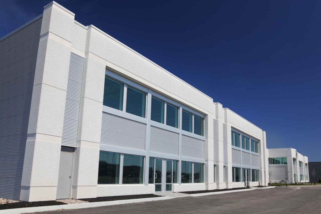 Modern two-story commercial building specializing in water filtration, with large windows and white facade under a clear blue sky.