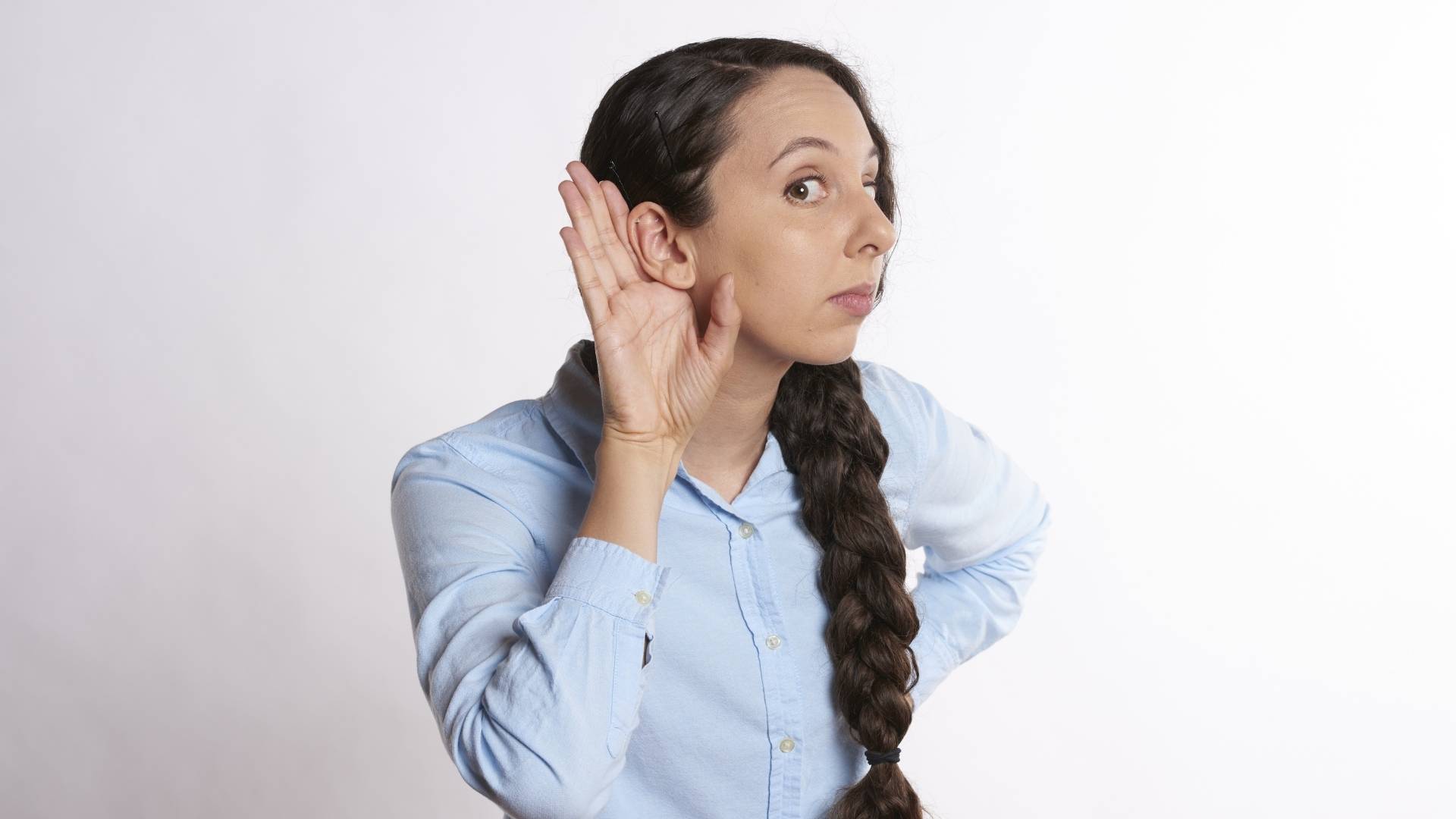 woman listening with her hand over her ear