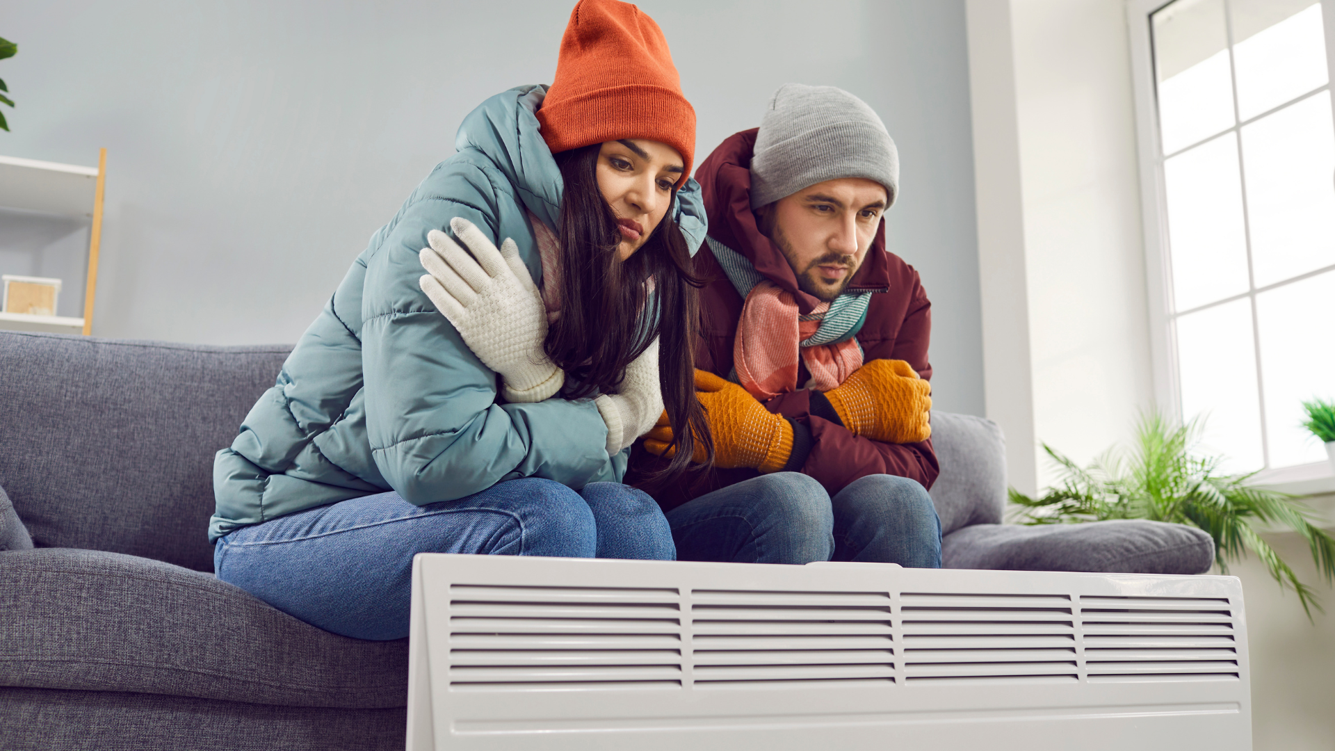Man and Woman bundled next to broken heater