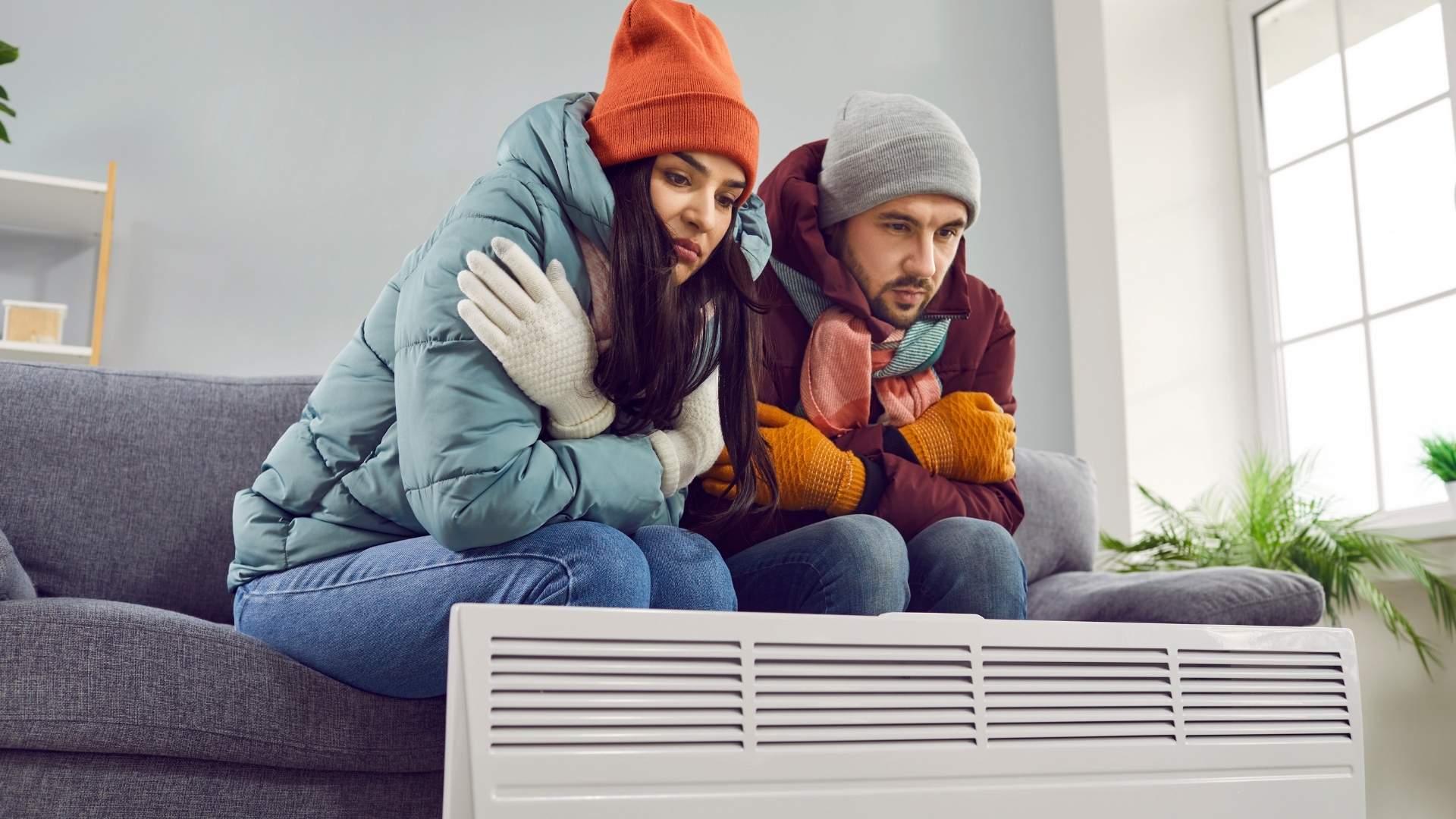 Man and Woman bundled next to broken heater