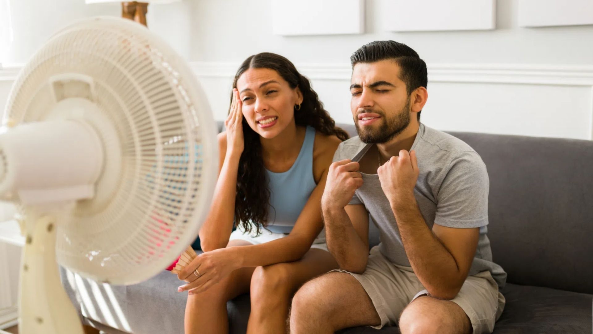 Woman and Man use fan to cool down instead of AC or dehumidifier