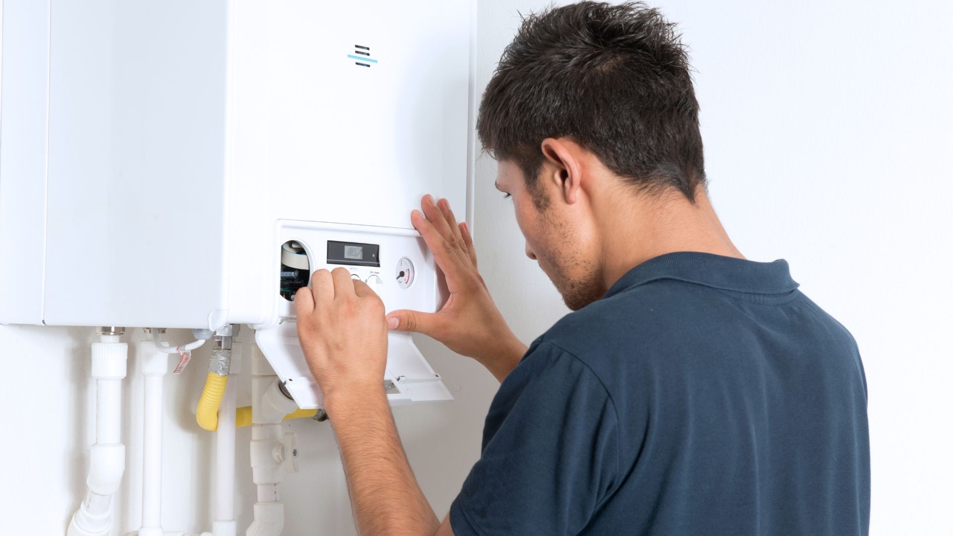 boiler maintenance in Michigan man in black shirt fixing boiler