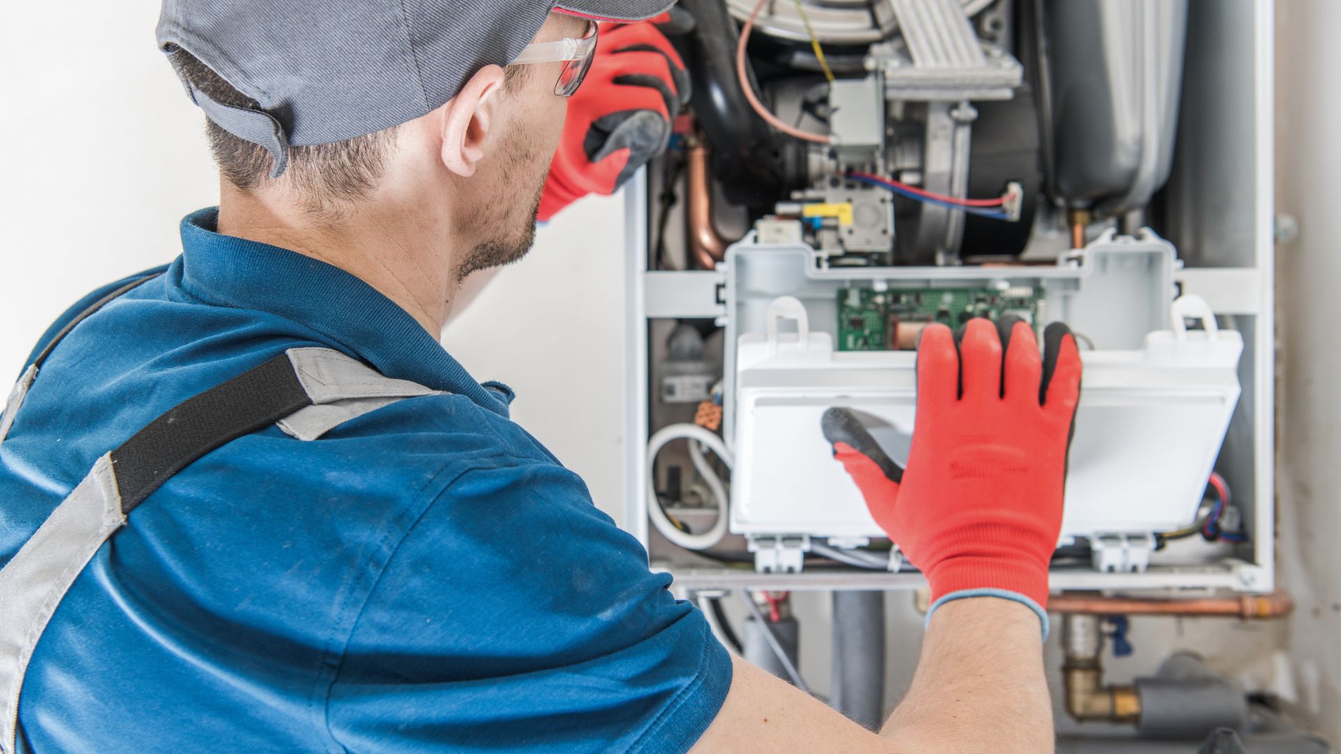 HVAC man repairing heater unit